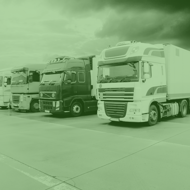 Fila de camiones de carga estacionados en un patio logístico, listos para operar con un suministro eficiente de combustible