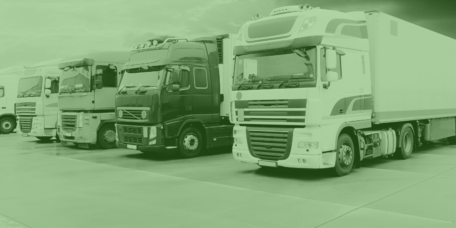 Fila de camiones de carga estacionados en un patio logístico, listos para operar con un suministro eficiente de combustible