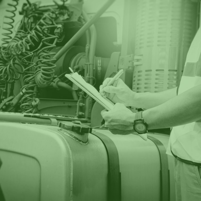 Inspector revisando una lista de verificación en una estación de carga de combustible para transporte de carga de forma confiable